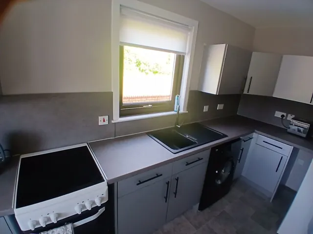After: the same kitchen wrapped in light grey matt with a dark worktop