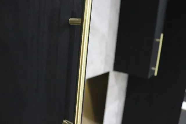 Black woodgrain wrapped doors with long gold handles