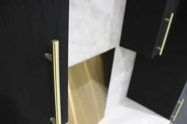 Wrapped black doors and drawer fronts with gold handles