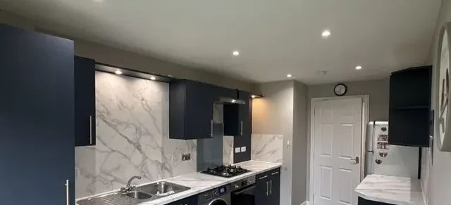 Navy wrapped kitchen with marble-effect splashback in Glasgow