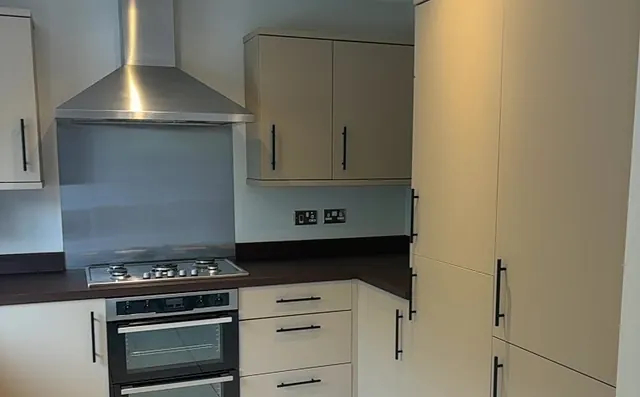 Kitchen wrapped in warm taupe matt with tall larder units