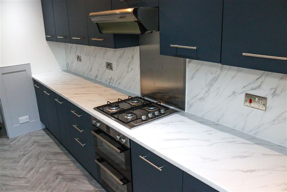 Navy wrapped kitchen with marble-effect worktop